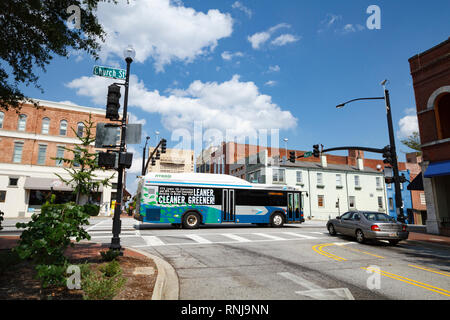 Un nouvel hybride fossiles Sparte transport en commun autobus passe par l'intersection de la rue principale et l'église de Spartanburg, SC sur une journée ensoleillée dans Banque D'Images