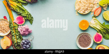 Divers ingrédients végétaliens sains : fruits, légumes et baies avec amandes, graines de chia et les pignons de pin, vue du dessus, frame Banque D'Images