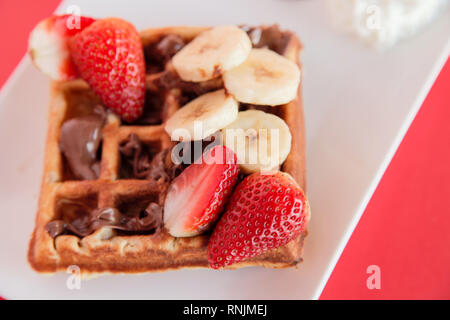 Fraise et banane gaufre sur fond rouge libre Banque D'Images