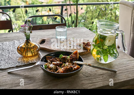 Tranches de pizza végétarienne dans un bol et sombre sur une planche en bois sur la table dans le café sur fond nature. Près de il y a un verre à limonade, glas Banque D'Images