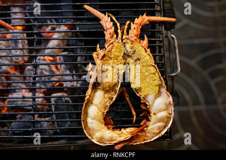 Homard appétissant est cuit sur le gril sur le marché de l'alimentation de rue à Bangkok en Thaïlande. Vue de dessus Gros plan photo. L'horizontale. Banque D'Images