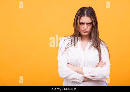 Jeune femme en colère casualy habillé debout sur fond jaune. L'expression faciale Banque D'Images