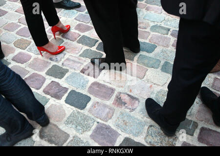 Gros plan sur les pieds d'une femme portant des talons et des pieds d'hommes portant des chaussures à puce Banque D'Images