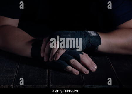 Mains de fighter dans un style moderne sur fond noir. Concept de soins de santé. Corps musculaire remise en forme. Mode de vie sain. Fond sombre. Banque D'Images
