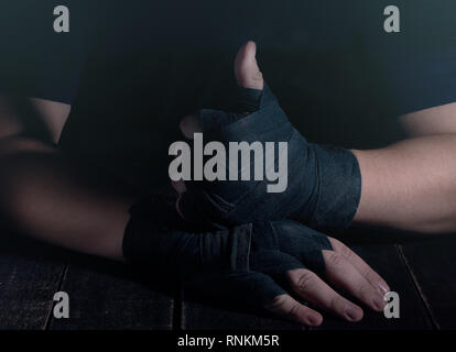 Mains de fighter dans un style moderne sur fond noir. Concept de soins de santé. Corps musculaire remise en forme. Mode de vie sain. Fond sombre. Banque D'Images