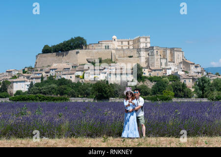 Couple de touristes chinois à prendre des photos de l'autre dans un champ de lavande à Grignan *** *** légende locale Banque D'Images