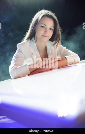 Femme avec le piano blanc sur la scène. Banque D'Images