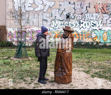 Berlin Mitte, Heinrich-Zille-Park, un homme âgé et sculpture en bois de l'homme avec réserve en aire de jeux pour enfants à 20, Banque D'Images