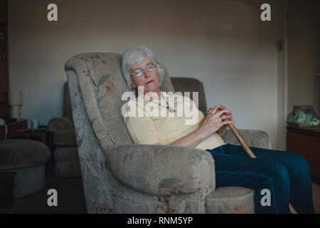 Senior woman est endormi dans un fauteuil dans le salon de sa maison. Banque D'Images