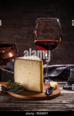 Verre de vin rouge et fromage nature morte sur fond de bois Banque D'Images