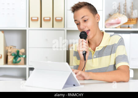 Portrait d'un jeune garçon singing karaoke Banque D'Images