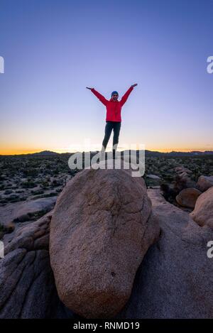 Jeune femme debout avec les bras tendus sur les roches de granit ronds au coucher du soleil, des formations rocheuses, réservoir Blanc Campground Banque D'Images