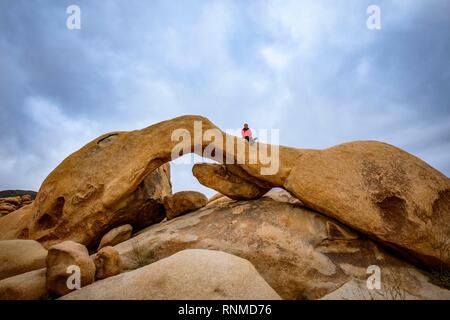 Jeune femme assise sur Arch Rock, Rock arch, formation, Arch Rock monzogranite sentier nature, camping réservoir Blanc Banque D'Images