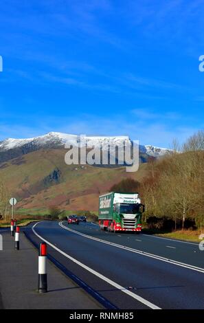 Eddie Stobart camion, la principale A66 Route de la Lake District, Cumbria, Angleterre Royaume-uni - avec enneigés des montagnes Blencathra visibles à l'horizon. Banque D'Images