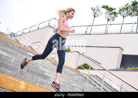 Sérieux au sujet de rester en forme. Vue de dessus de jeune femme en vêtements de sport jogging lors de l'exercice Banque D'Images