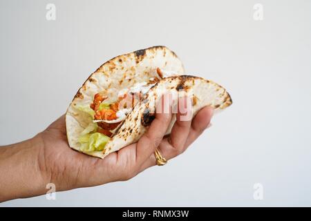 Femme hand holding Soft tacos au poisson isolé sur blanc, selective focus Banque D'Images