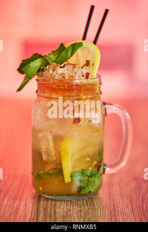 Froid limonade rafraîchissante de chili avec une menthe garnir en pot Mason sur fond rouge Banque D'Images