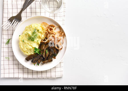 Tranches de foie de boeuf grillé avec purée de pommes de terre et d'oignon frit sur plaque blanche sur fond de pierre avec l'exemplaire de l'espace. Pièces foie (abats) de b Banque D'Images