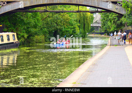 Les gens qui marchent le long du Regent's Canal avec groupe d'canoë en passant sous le pont en été Banque D'Images