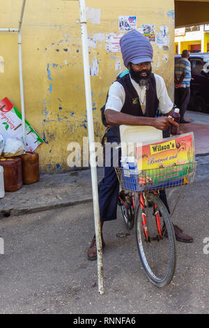 Cette betterave de Wilson et le jus de carottes vendeur vend bouteilles de jus à partir de sa bicyclette. Banque D'Images