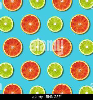 Rouge vibrant orange et vert lime les tranches de citron sur fond de couleur turquoise. Un minimum de mise à plat Vue de dessus la texture des aliments Banque D'Images