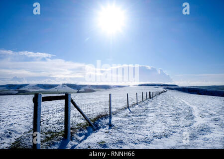 Une longue clôture avec une perspective décroissants assis sur le haut du mont Caburn couvertes de neige blanche, Lewes, East Sussex, Royaume-Uni, couverts de neige ro Banque D'Images