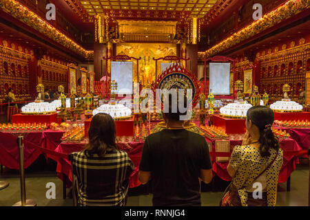 Fidèles bouddhistes priant à l'entrée Grande salle de prière, Buddha Tooth Relic Temple, Singapour. Banque D'Images