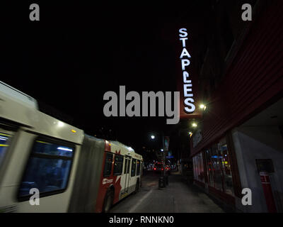 OTTAWA, CANADA - 11 NOVEMBRE 2018 : Bus passant devant un logo agrafes devant leur magasin au centre-ville d'Ottawa (Ontario) la nuit. Staples est un Banque D'Images