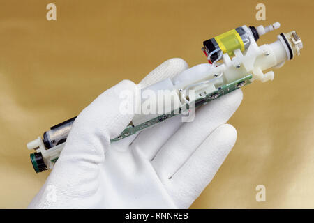 Technicien vérifie la qualité de l'appareil électro-mécanique avec batterie et moteur. La société de production. Studio concept macro Banque D'Images