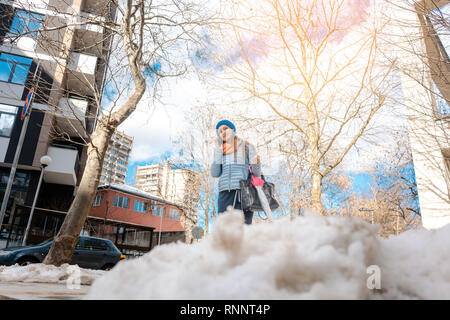 Femme marchant dans la neige à la fin de l'hiver Banque D'Images