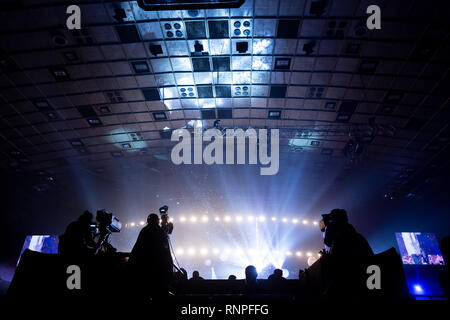 Un groupe de travail de cameramen pendant le concert. Nombre d'événement. Silhouettes d'ouvriers contre l'arrière-plan de faisceaux colorés. Banque D'Images