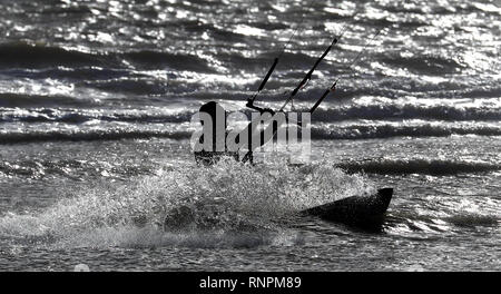 Un kitesurfeur sur la côte dans le carrossage, East Sussex, météo week-end chaud va voir les températures s'élèvent à près d'un niveau record pour février, le Met Office a dit. Banque D'Images