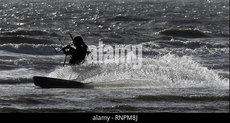 Un kitesurfeur sur la côte dans le carrossage, East Sussex, météo week-end chaud va voir les températures s'élèvent à près d'un niveau record pour février, le Met Office a dit. Banque D'Images