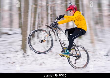 Garçon, 14 ans, le VTT dans les bois dans la neige, Bade-Wurtemberg, Allemagne Banque D'Images