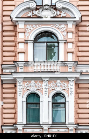 Trois fenêtres cintrées de stuc blanc sur le fond du mur en rose. À partir d'une série de fenêtres de Saint-Pétersbourg. Banque D'Images