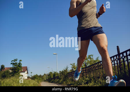 Pied runner close-up sur la route dans le parc Banque D'Images