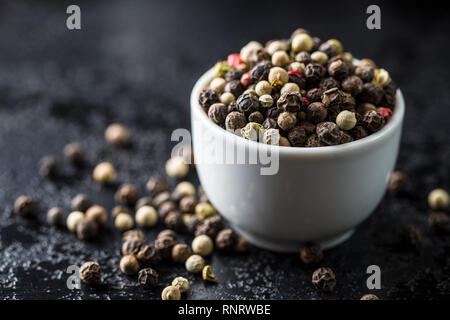 Différents types de grains de poivre dans un bol. Banque D'Images