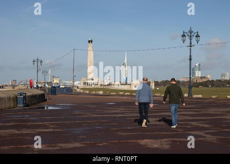 Les hommes à marcher le long de l'esplanade Southsea avec Spinnaker Tower Views, Southsea, Portsmouth, Royaume-Uni Banque D'Images