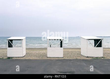 L'évolution du public en bois blanc trois huttes sur la plage de galets à Weymouth, Dorset, UK, sous un ciel couvert journée d'été Banque D'Images