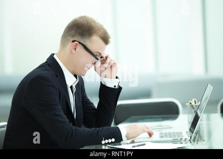 Jeune homme d'affaires utilise un ordinateur portable dans le bureau. Banque D'Images