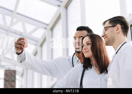 Groupe de médecins stagiaires en tenant vos autoportraits dans le hall de l'hôpital Banque D'Images
