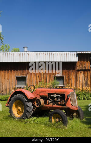 Vieux tracteur agricole Cockshutt 1948 en face de l'ancienne grange en bois Banque D'Images