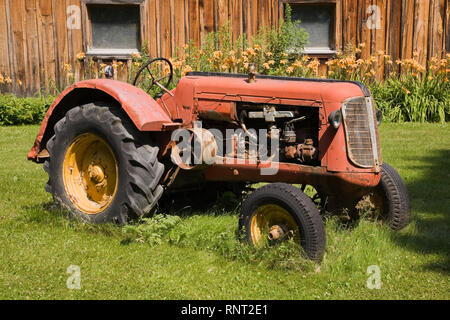 Vieux tracteur agricole Cockshutt 1948 en face de l'ancienne grange en bois Banque D'Images