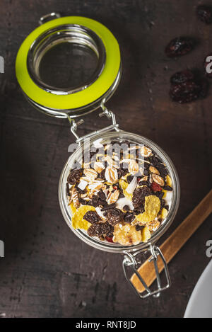 Photo verticale avec vue de dessus sur le yaourt blanc. Le yaourt est en petit pot de verre avec métal serrure et couvercle hermétique. Muesli avec des aliments secs est stratifié en et Banque D'Images