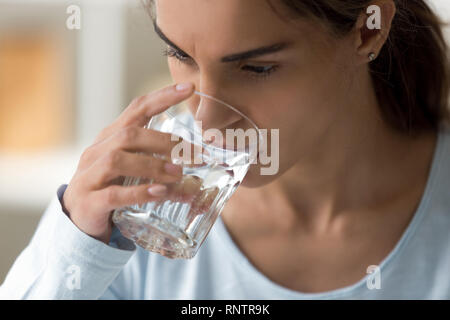 Close up visage féminin holding glass of water Banque D'Images