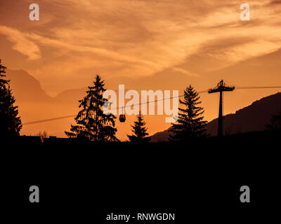 Image de silhouettes de téléski et des arbres au lever du soleil tôt le matin avec de l'air et les nuages colorés Banque D'Images