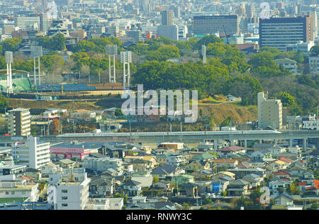 Le Kyushu Shinkansen japonais (ligne ferroviaire à grande vitesse) avec Château Kumamoto en réparation en arrière-plan Banque D'Images