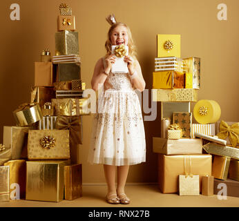 Portrait de jeune fille en robe beige monter et l'arrondi et un peu sur la tête de la Couronne à partir de Tablet PC avec des piles de 2 bow Banque D'Images