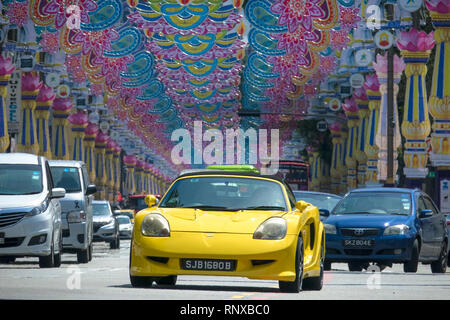 Voiture jaune sportif dans la circulation en vertu de la Deepavali Festival Decorations - Little India, Singapour Banque D'Images