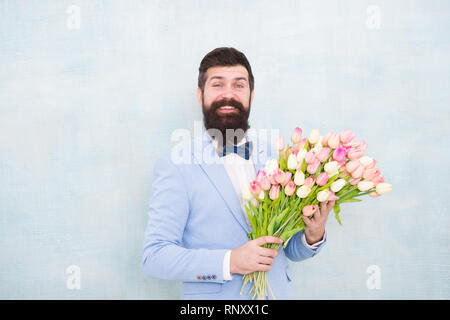 Tulipes pour ma chérie. Homme très soigné porter Bow-tie tuxedo tenir fleurs bouquet. Inviter ses sorties. Homme romantique avec des fleurs. Cadeau romantique. Macho prêt date romantique. En attente de Darling. Banque D'Images